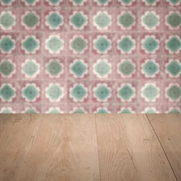 Wood table top and blur vintage ceramic tile pattern wall — Stock Photo, Image