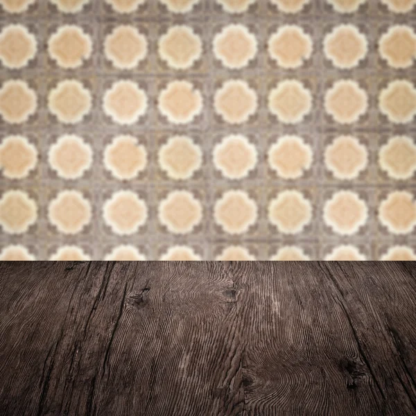 Wood table top and blur vintage ceramic tile pattern wall — Stock Photo, Image