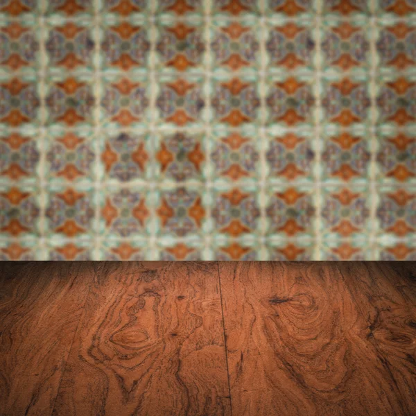 Wood table top and blur vintage ceramic tile pattern wall — Stock Photo, Image