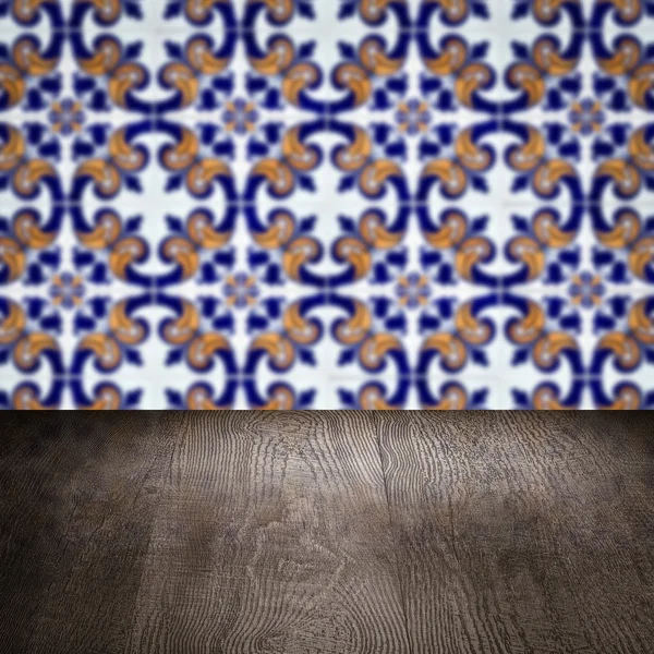 Wood table top and blur vintage ceramic tile pattern wall — Stock Photo, Image