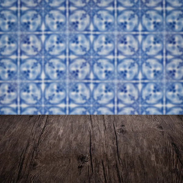 Wood table top and blur vintage ceramic tile pattern wall — Stock Photo, Image