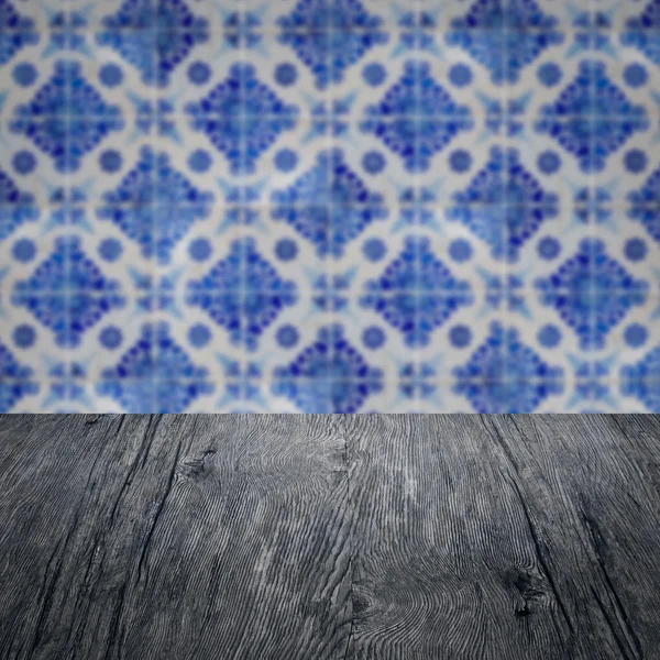 Wood table top and blur vintage ceramic tile pattern wall — Stock Photo, Image