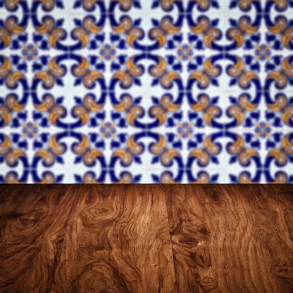 Wood table top and blur vintage ceramic tile pattern wall — Stock Photo, Image