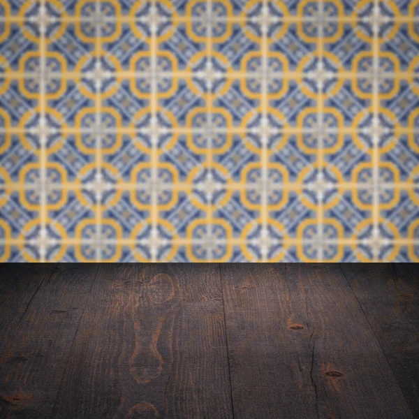 Houten tafelblad en vervagen ceramiektegel patroon muur — Stockfoto