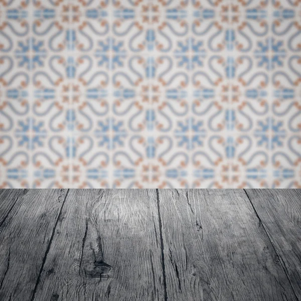 Wood table top and blur vintage ceramic tile pattern wall — Stock Photo, Image