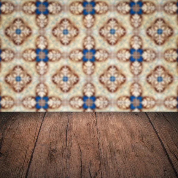 Wood table top and blur vintage ceramic tile pattern wall — Stock Photo, Image