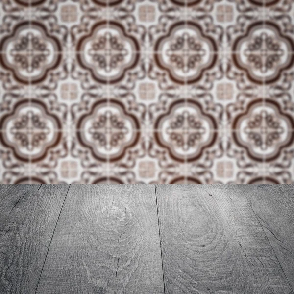 Wood table top and blur vintage ceramic tile pattern wall — Stock Photo, Image