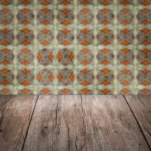 Wood table top and blur vintage ceramic tile pattern wall — Stock Photo, Image