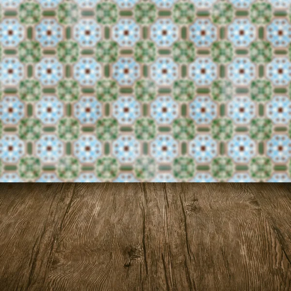 Wood table top and blur vintage ceramic tile pattern wall — Stock Photo, Image