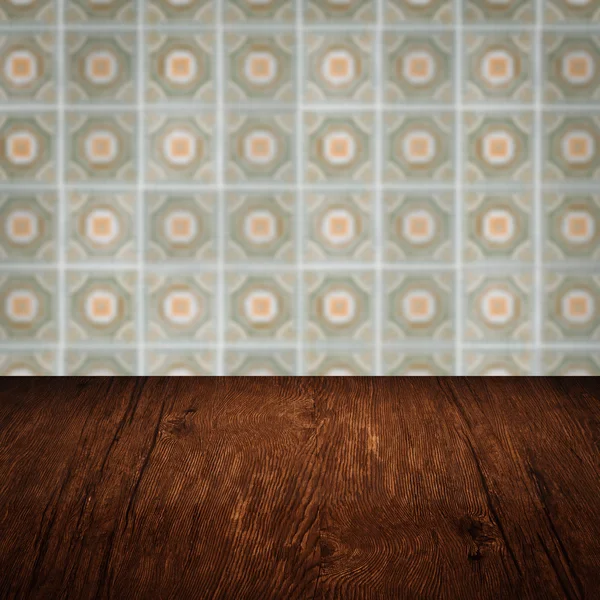 Wood table top and blur vintage ceramic tile pattern wall — Stock Photo, Image