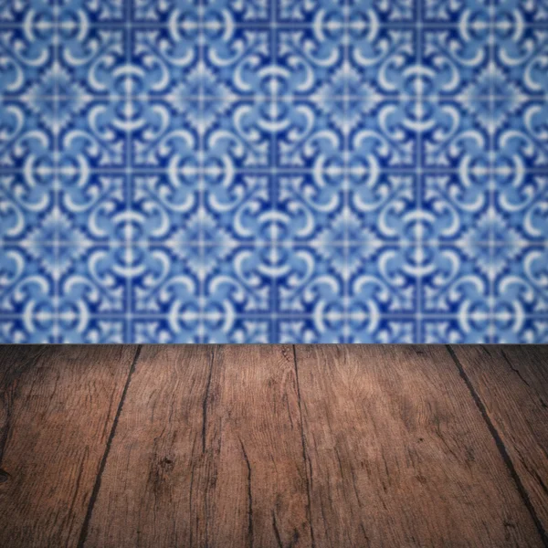 Wood table top and blur vintage ceramic tile pattern wall — Stock Photo, Image