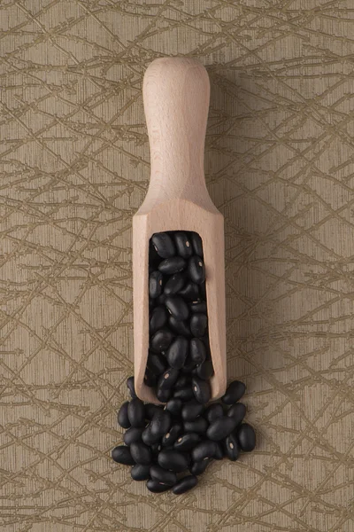 Drewniana miarka z czarnej fasoli — Zdjęcie stockowe