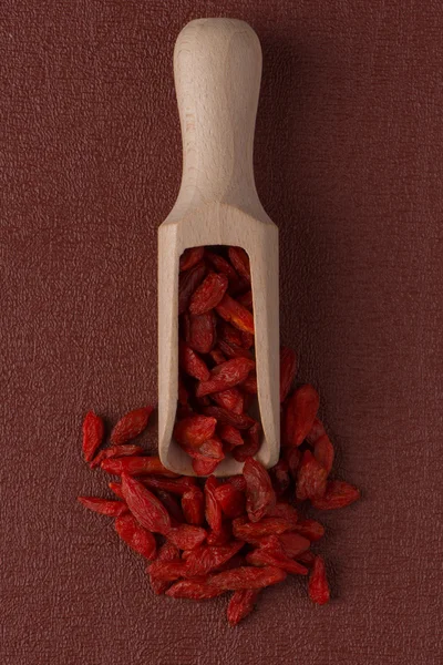 Pala de madera con bayas rojas secas de goji — Foto de Stock