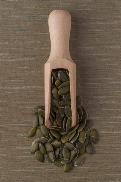 Wooden scoop with pumpkin seeds — Stock Photo, Image