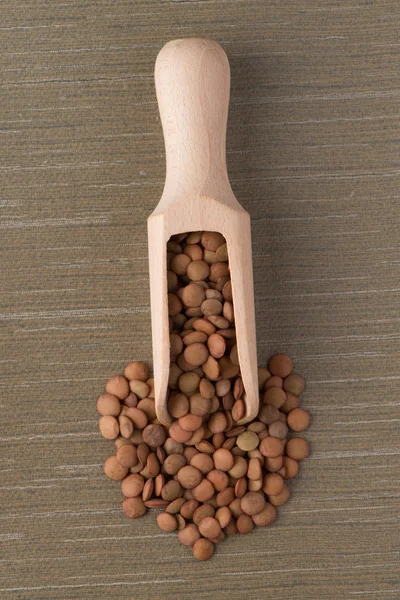 Wooden scoop with lentils — Stock Photo, Image