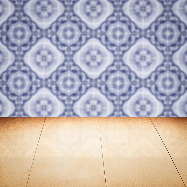 Wood table top and blur vintage ceramic tile pattern wall — Stock Photo, Image