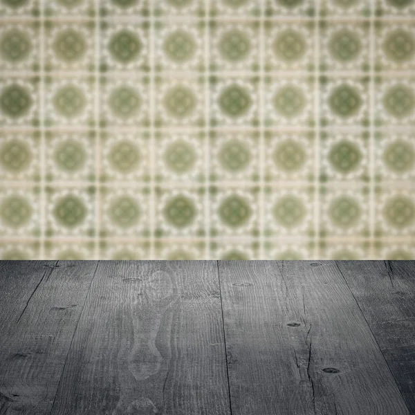 Wood table top and blur vintage ceramic tile pattern wall — Stock Photo, Image