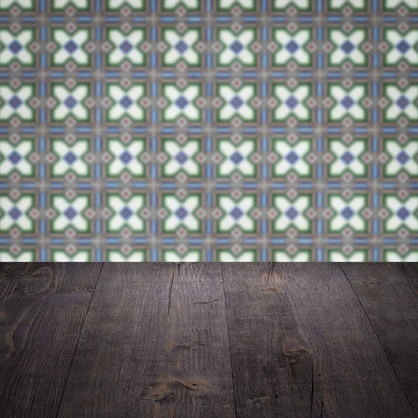 Wood table top and blur vintage ceramic tile pattern wall — Stock Photo, Image