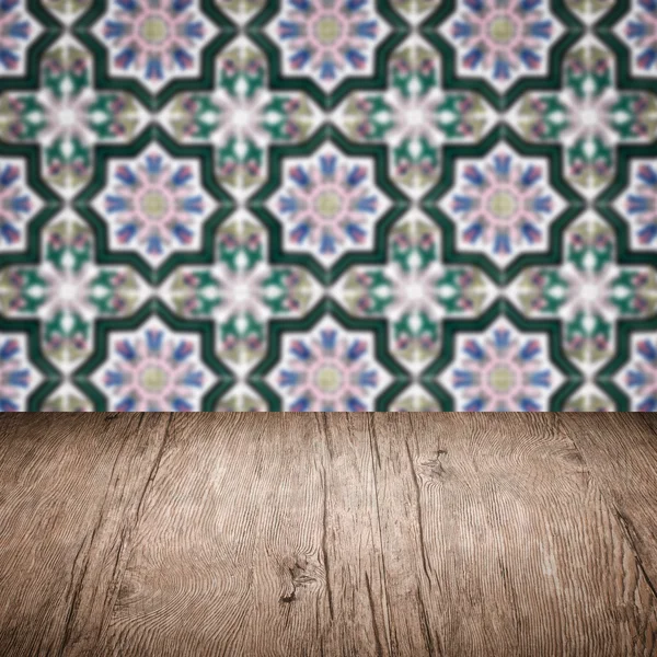 Wood table top and blur vintage ceramic tile pattern wall — Stock Photo, Image