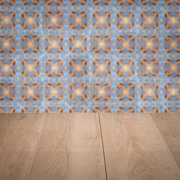 Wood table top and blur vintage ceramic tile pattern wall — Stock Photo, Image