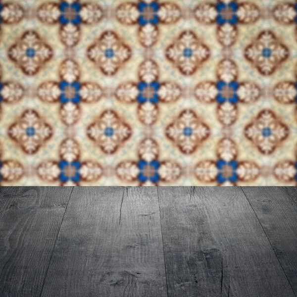 Wood table top and blur vintage ceramic tile pattern wall — Stock Photo, Image