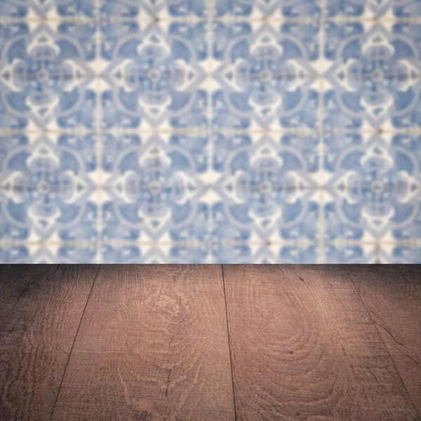 Wood table top and blur vintage ceramic tile pattern wall — Stock Photo, Image