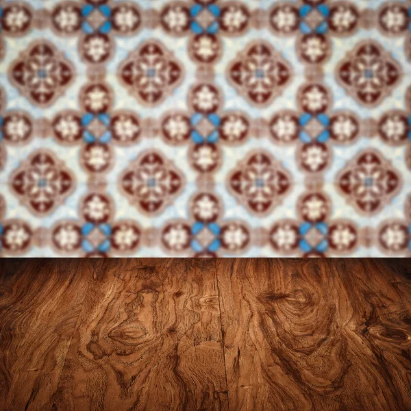 Wood table top and blur vintage ceramic tile pattern wall — Stock Photo, Image