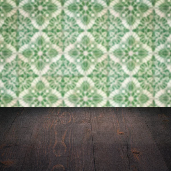 Wood table top and blur vintage ceramic tile pattern wall — Stock Photo, Image