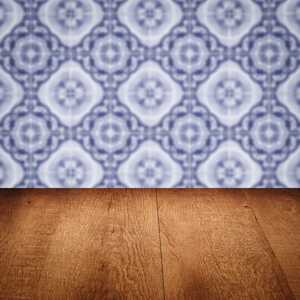 Wood table top and blur vintage ceramic tile pattern wall — Stock Photo, Image