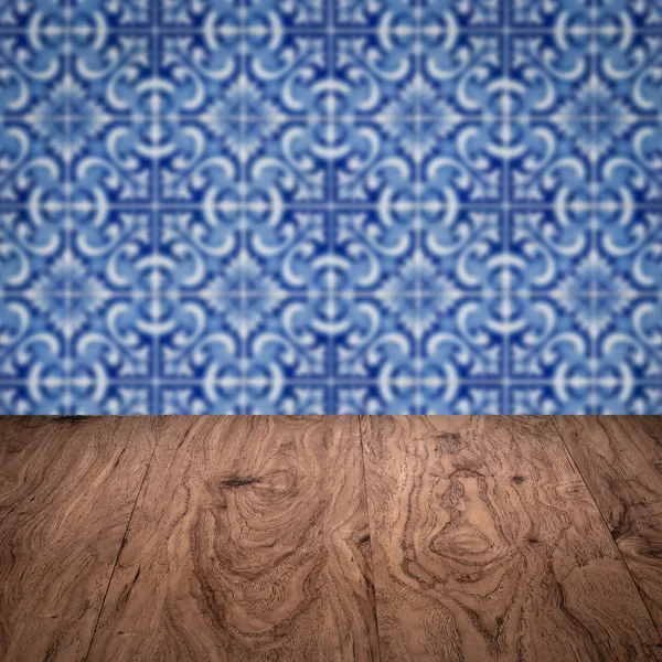 Wood table top and blur vintage ceramic tile pattern wall — Stock Photo, Image