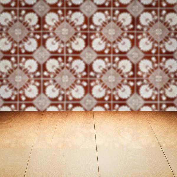 Wood table top and blur vintage ceramic tile pattern wall — Stock Photo, Image