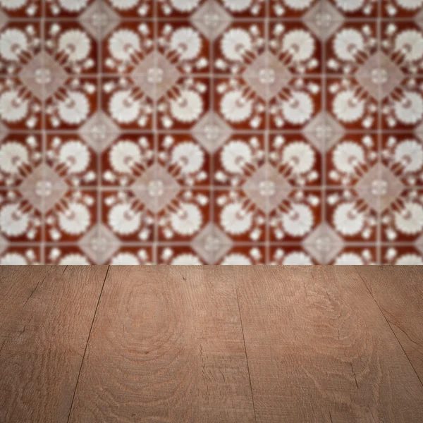 Wood table top and blur vintage ceramic tile pattern wall — Stock Photo, Image