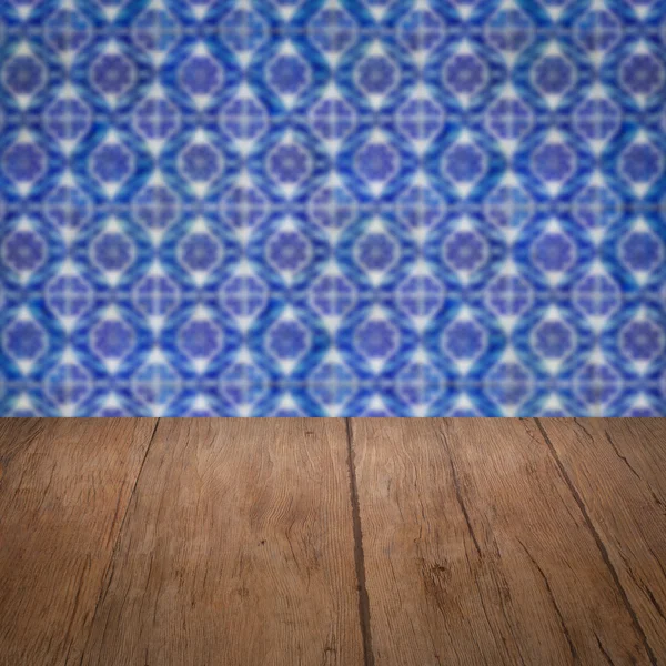 Wood table top and blur vintage ceramic tile pattern wall — Stock Photo, Image