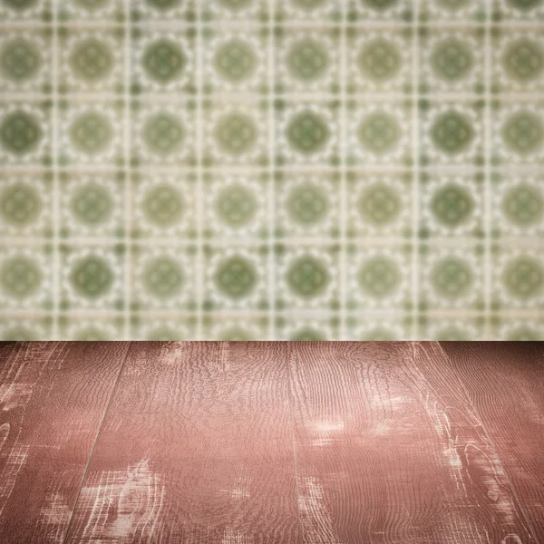 Wood table top and blur vintage ceramic tile pattern wall — Stock Photo, Image