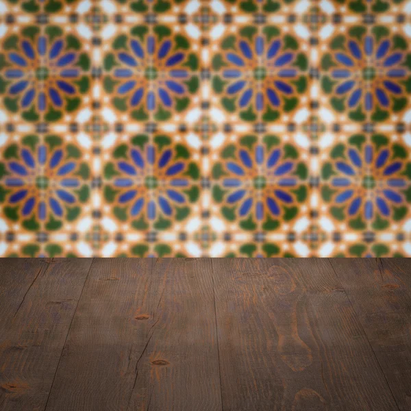 Wood table top and blur vintage ceramic tile pattern wall — Stock Photo, Image