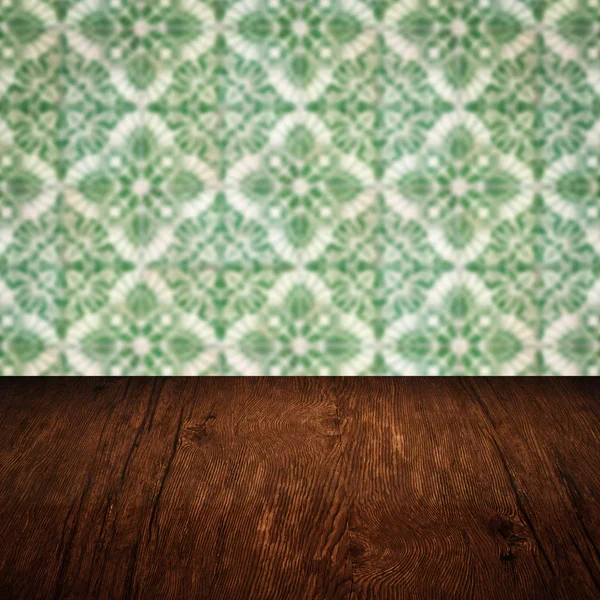 Wood table top and blur vintage ceramic tile pattern wall — Stock Photo, Image