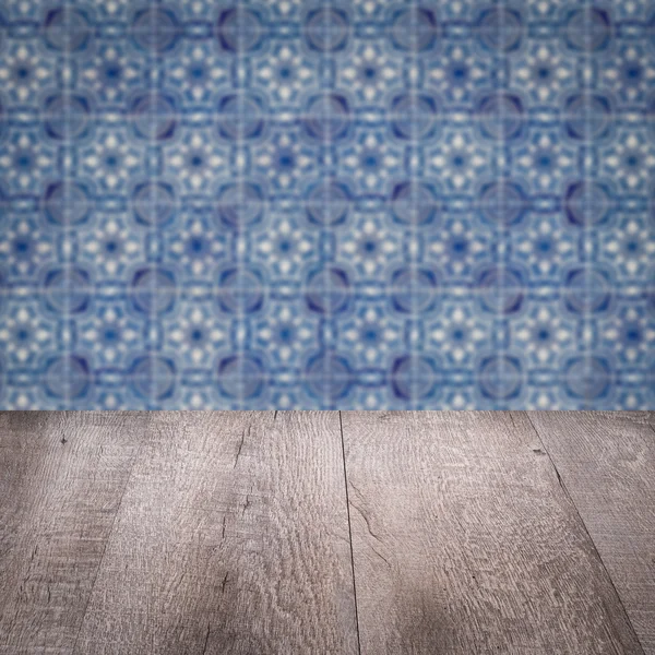 Wood table top and blur vintage ceramic tile pattern wall — Stock Photo, Image