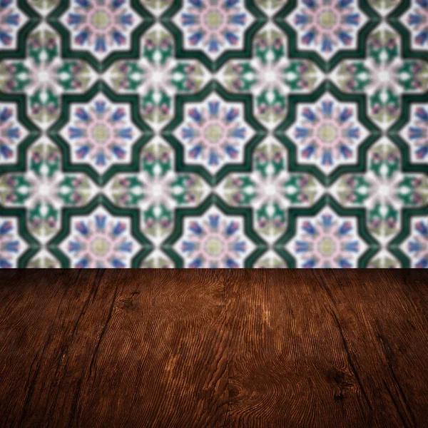 Wood table top and blur vintage ceramic tile pattern wall — Stock Photo, Image