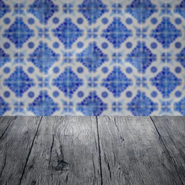 Wood table top and blur vintage ceramic tile pattern wall — Stock Photo, Image