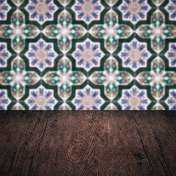 Wood table top and blur vintage ceramic tile pattern wall — Stock Photo, Image