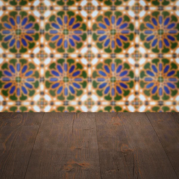 Wood table top and blur vintage ceramic tile pattern wall — Stock Photo, Image