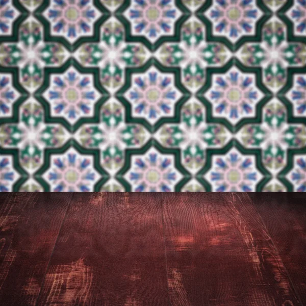 Wood table top and blur vintage ceramic tile pattern wall — Stock Photo, Image