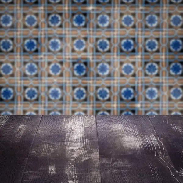 Wood table top and blur vintage ceramic tile pattern wall — Stock Photo, Image