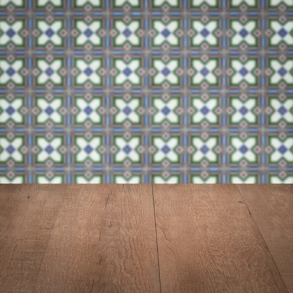 Wood table top and blur vintage ceramic tile pattern wall — Stock Photo, Image