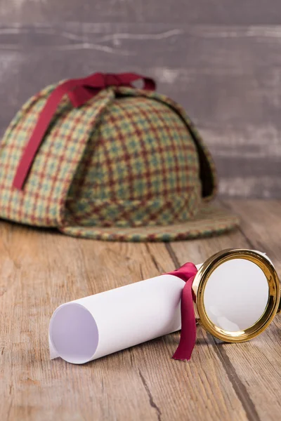 Wrapped paper sheets and magnifying glass — Stock Photo, Image