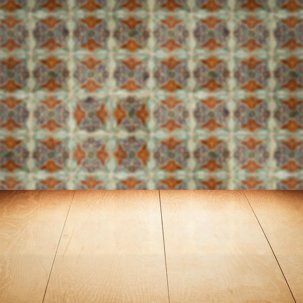 Wood table top and blur vintage ceramic tile pattern wall — Stock Photo, Image