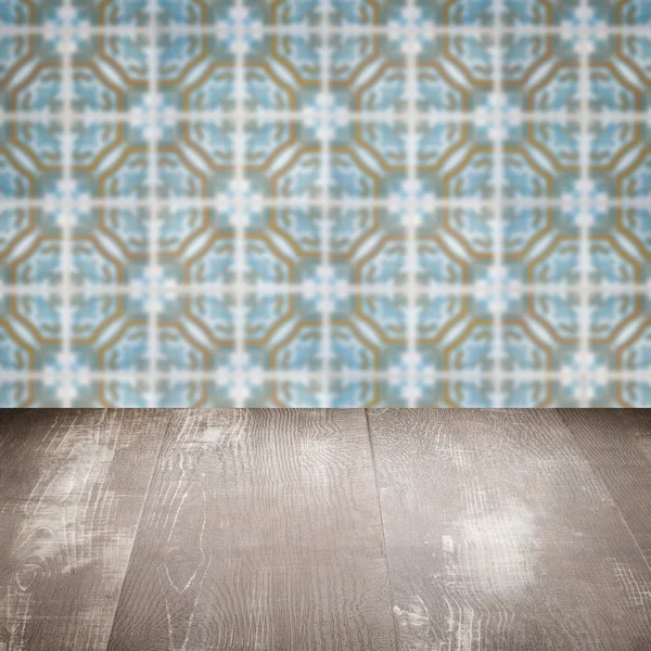 Wood table top and blur vintage ceramic tile pattern wall — Stock Photo, Image