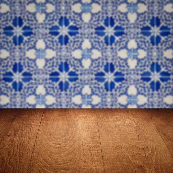 Wood table top and blur vintage ceramic tile pattern wall — Stock Photo, Image