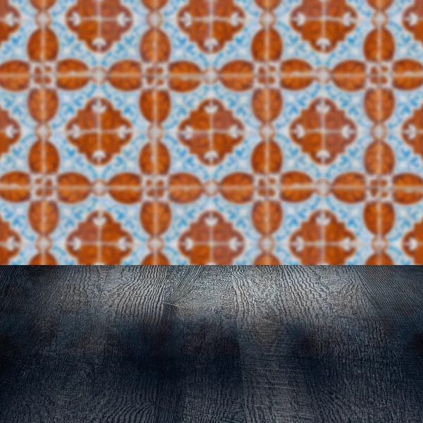 Wood table top and blur vintage ceramic tile pattern wall — Stock Photo, Image