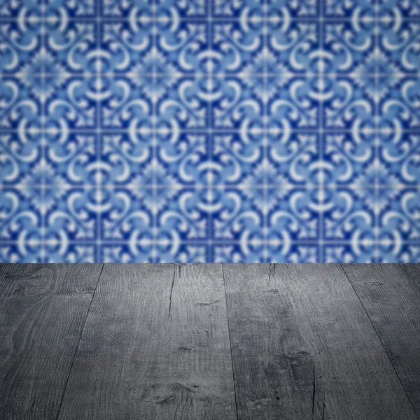 Wood table top and blur vintage ceramic tile pattern wall — Stock Photo, Image